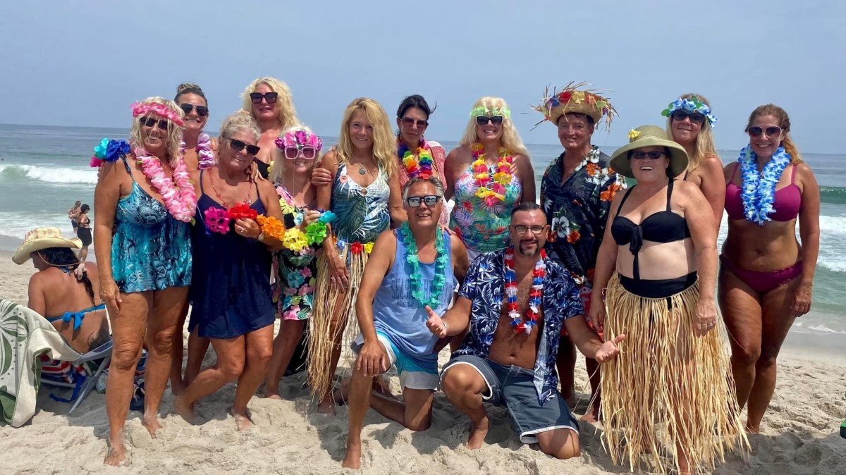 a group of people on a beach posing for the camera