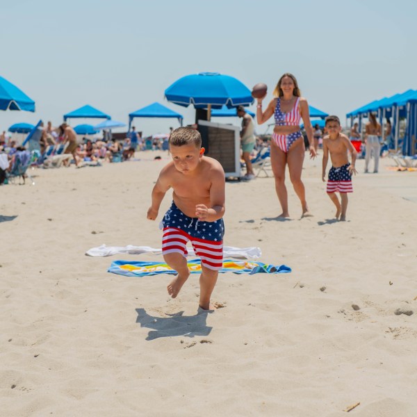a group of people standing on top of a sandy beach