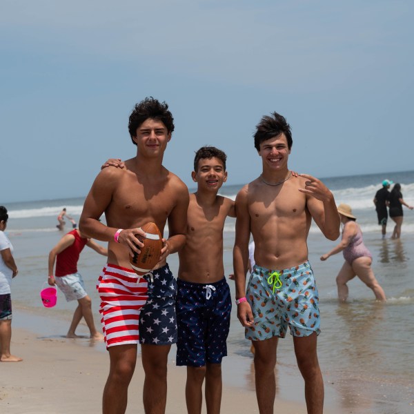 a group of people standing on top of a sandy beach