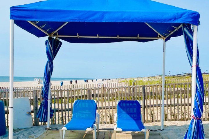 a group of people sitting at a table with a blue umbrella